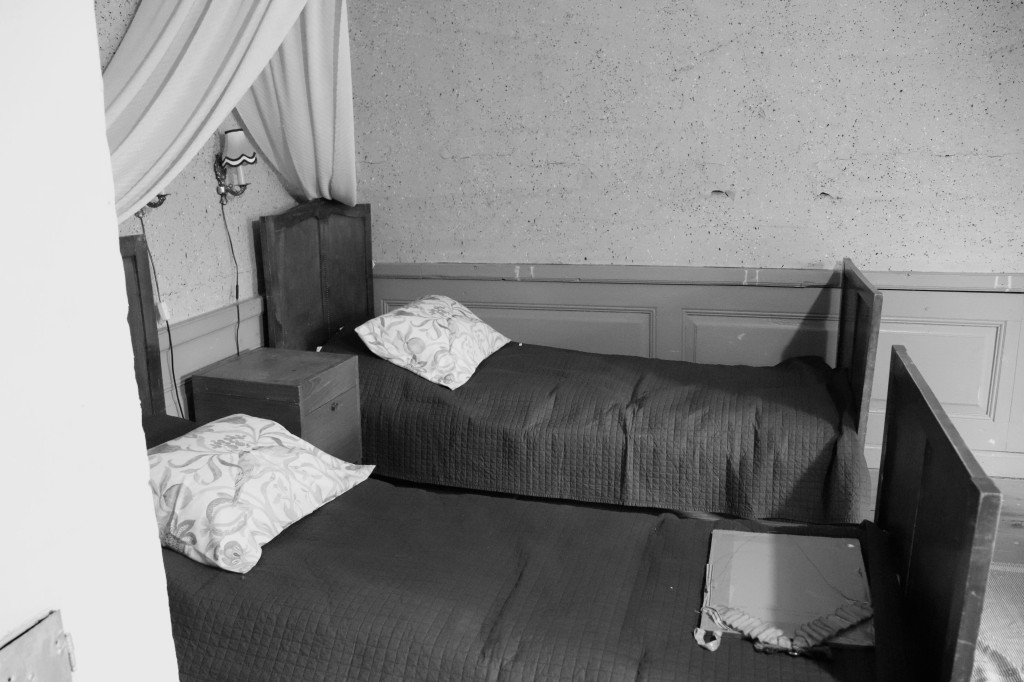 Kuva, jossa kaksi vanhanaikaista sänkyä.